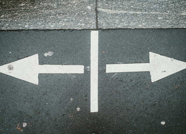 Flèches pointant dans des directions opposées sur une rue
